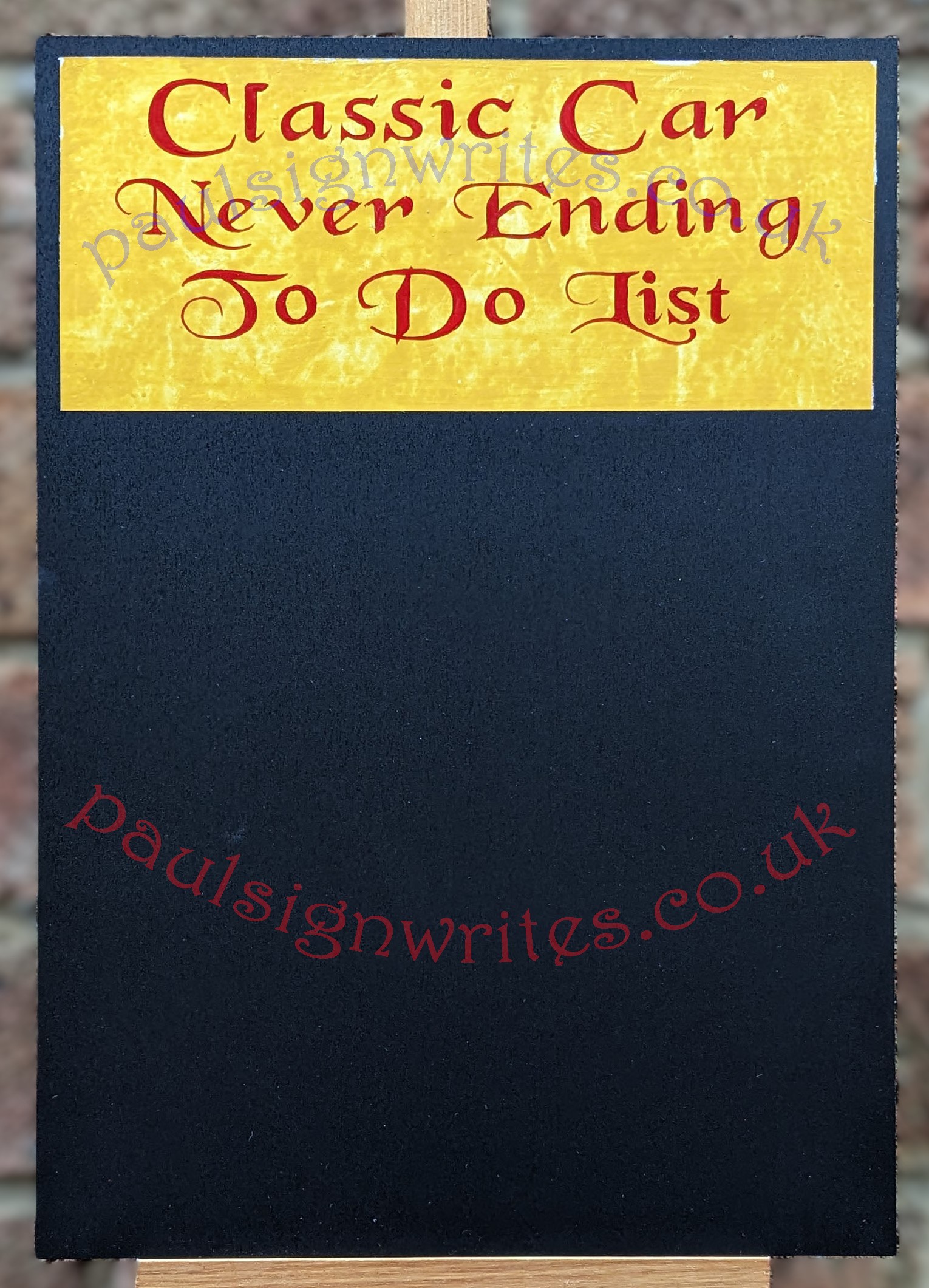 Blackboard, with signwritten 'Classic Car, Never Ending To Do List'  on a yellow painted panel.